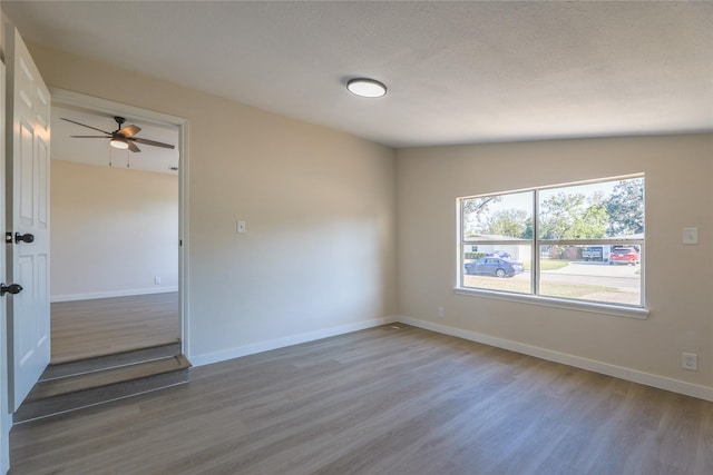 unfurnished room with ceiling fan, wood-type flooring, a textured ceiling, and lofted ceiling