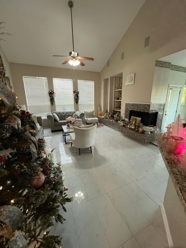 living room with ceiling fan and high vaulted ceiling