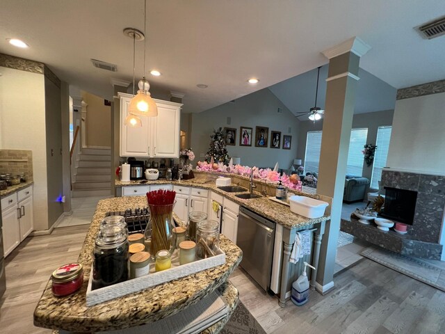 kitchen featuring dishwasher, sink, light hardwood / wood-style flooring, vaulted ceiling, and white cabinetry