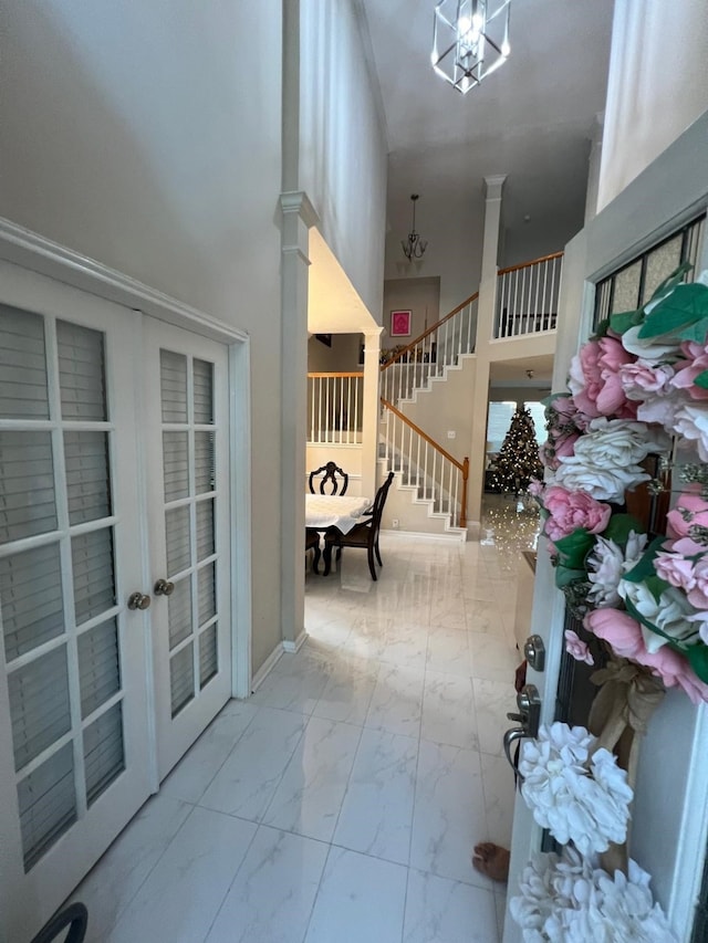 interior space featuring a high ceiling, decorative columns, and french doors