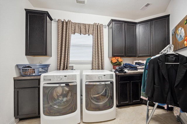 laundry area featuring light tile patterned floors, cabinets, and independent washer and dryer