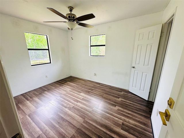 spare room with dark hardwood / wood-style floors, a wealth of natural light, and ceiling fan