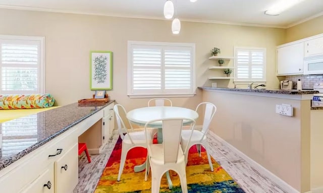 interior space with plenty of natural light, light wood-type flooring, and ornamental molding