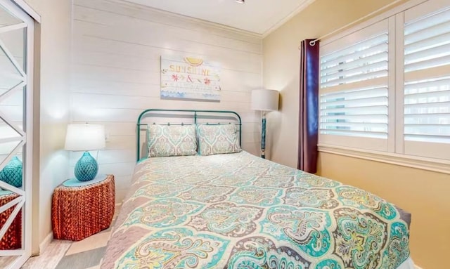 bedroom featuring crown molding and light hardwood / wood-style flooring