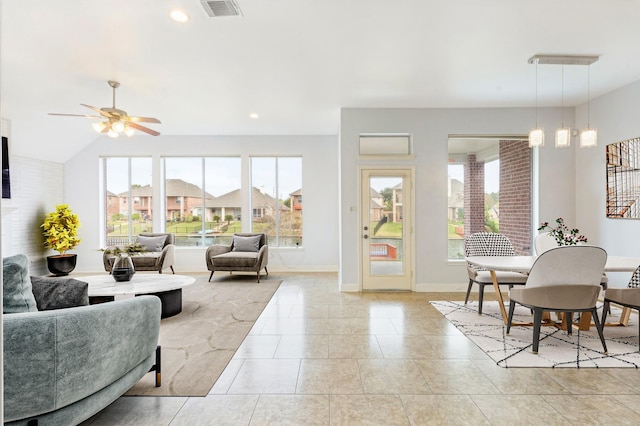 living room with ceiling fan, light tile patterned floors, a healthy amount of sunlight, and lofted ceiling