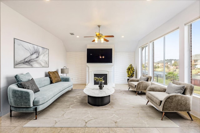 living room featuring ceiling fan, light tile patterned flooring, and vaulted ceiling