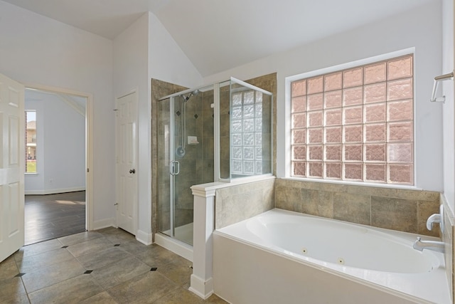 bathroom featuring tile patterned flooring, vaulted ceiling, and shower with separate bathtub