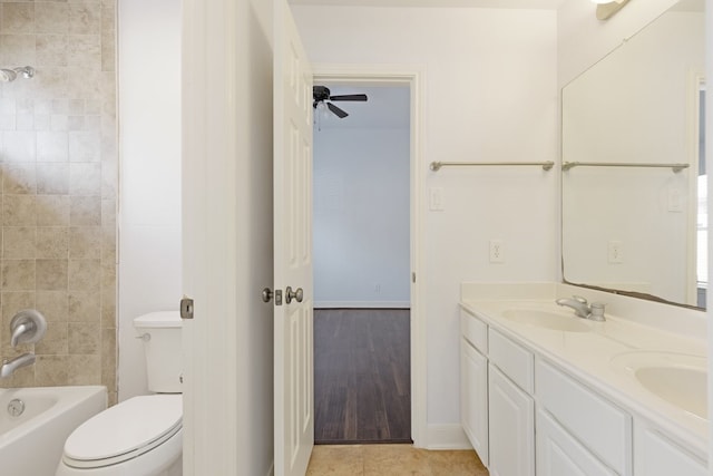 full bathroom with ceiling fan, tiled shower / bath combo, hardwood / wood-style floors, toilet, and vanity