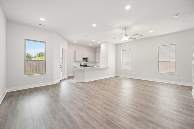 unfurnished living room featuring ceiling fan and hardwood / wood-style floors