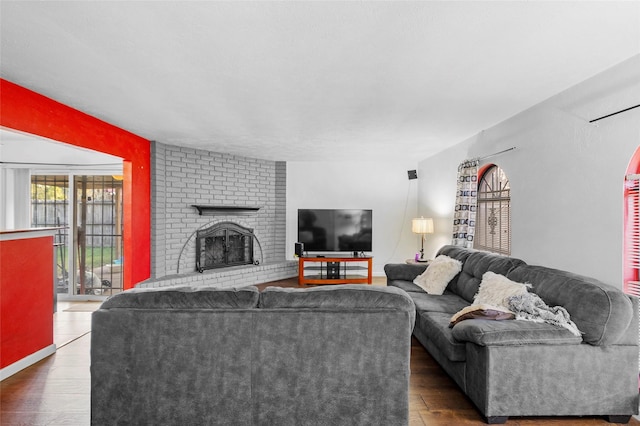 living room featuring dark hardwood / wood-style flooring and a brick fireplace