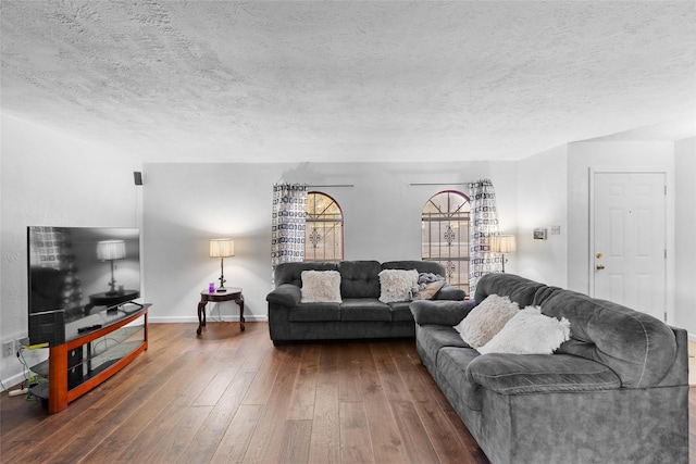 living room with dark hardwood / wood-style floors and a textured ceiling