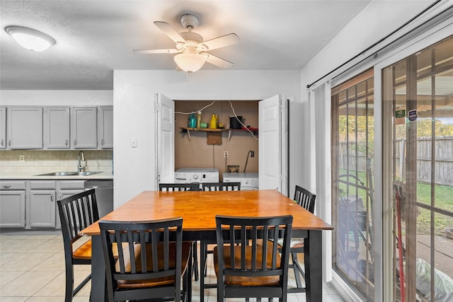 tiled dining room with a textured ceiling, separate washer and dryer, ceiling fan, and sink