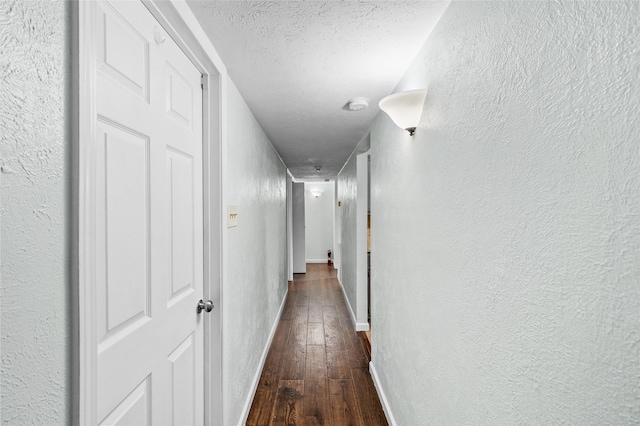 hall featuring dark hardwood / wood-style flooring and a textured ceiling