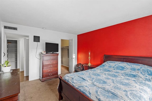 carpeted bedroom featuring a spacious closet and a closet