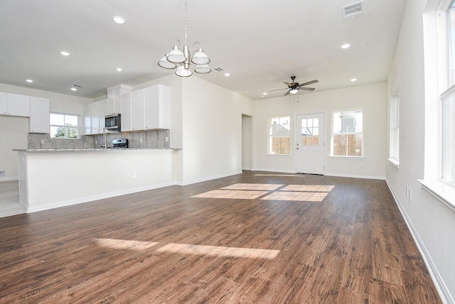 unfurnished living room featuring dark wood-type flooring and ceiling fan with notable chandelier