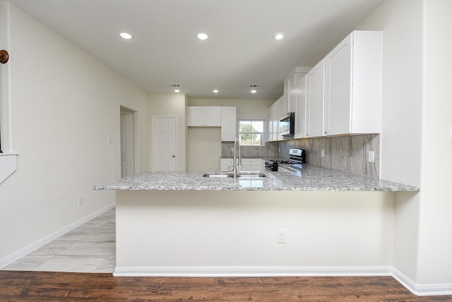 kitchen with kitchen peninsula, light wood-type flooring, and stainless steel appliances