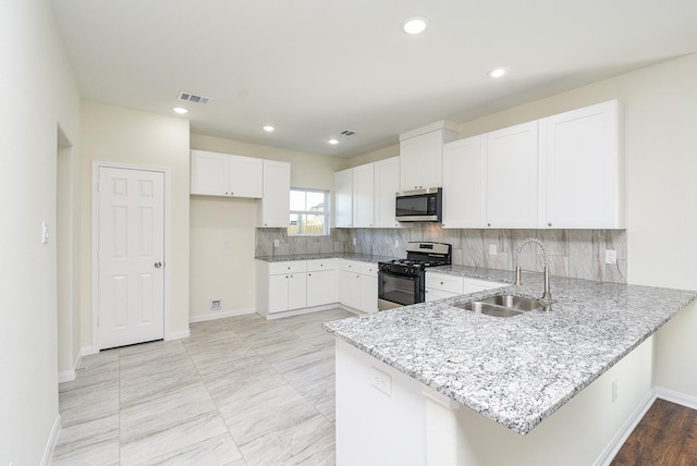 kitchen featuring sink, stainless steel appliances, backsplash, kitchen peninsula, and white cabinets