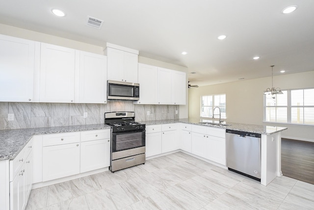 kitchen with kitchen peninsula, white cabinets, and appliances with stainless steel finishes