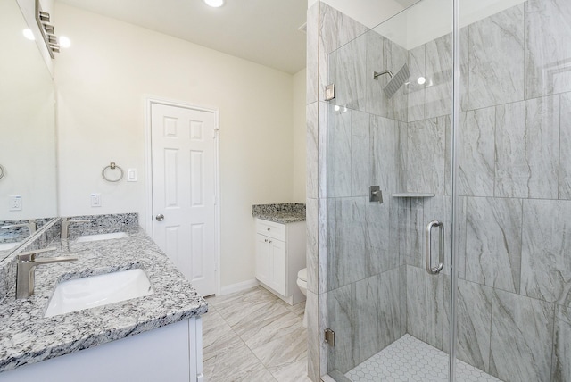 bathroom featuring a shower with door, vanity, and toilet