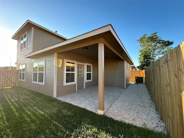 rear view of property with a yard and a patio