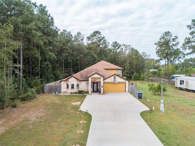 mediterranean / spanish house with a garage, central air condition unit, and a front lawn