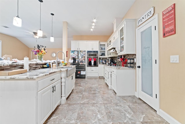 kitchen featuring light stone countertops, backsplash, ceiling fan, decorative light fixtures, and white cabinetry