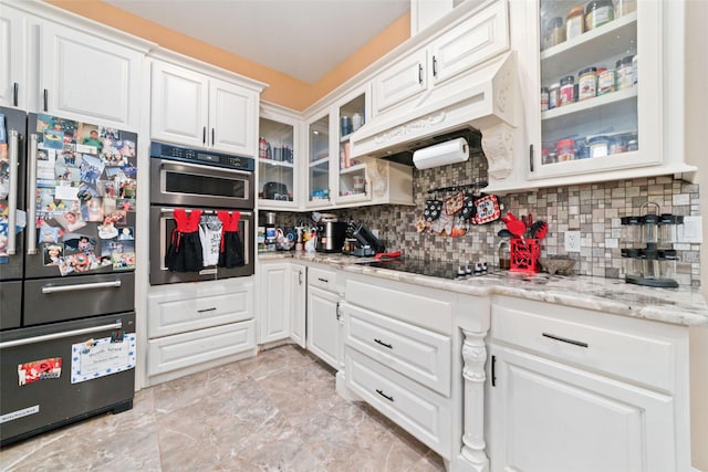 kitchen featuring stainless steel appliances, light stone counters, backsplash, extractor fan, and white cabinets