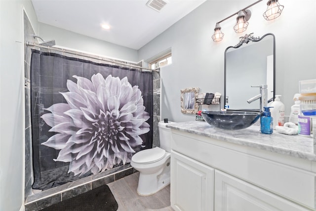 bathroom with hardwood / wood-style flooring, vanity, curtained shower, and toilet