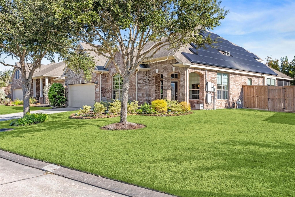 view of front of property with solar panels, a garage, and a front lawn