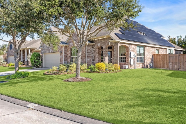 view of front of property with solar panels, a garage, and a front lawn