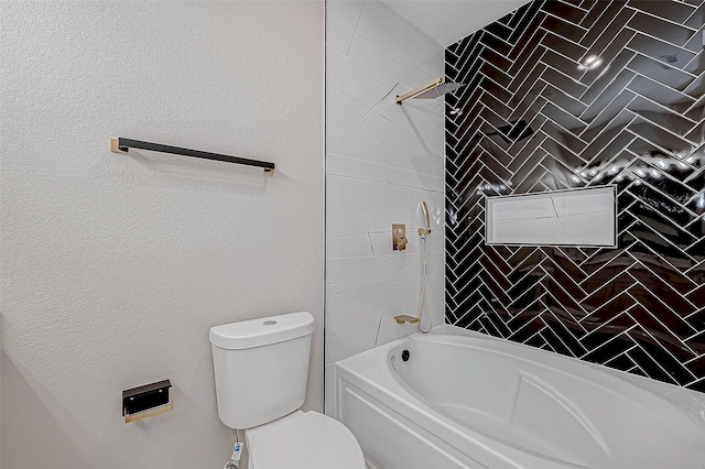 bathroom with toilet and tiled shower / bath