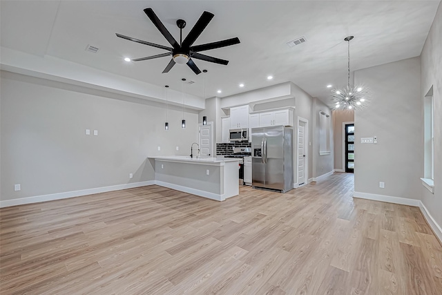 unfurnished living room with light wood-type flooring, ceiling fan with notable chandelier, and sink