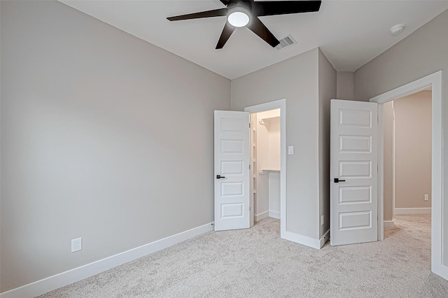 unfurnished bedroom featuring ceiling fan and light colored carpet