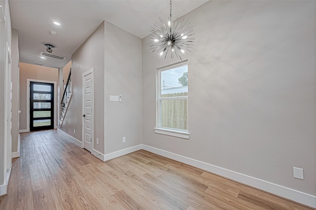 foyer entrance featuring light wood-type flooring and an inviting chandelier