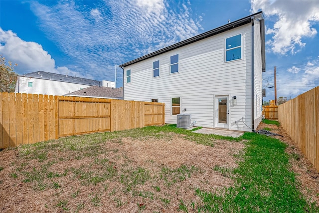 rear view of property featuring cooling unit and a yard