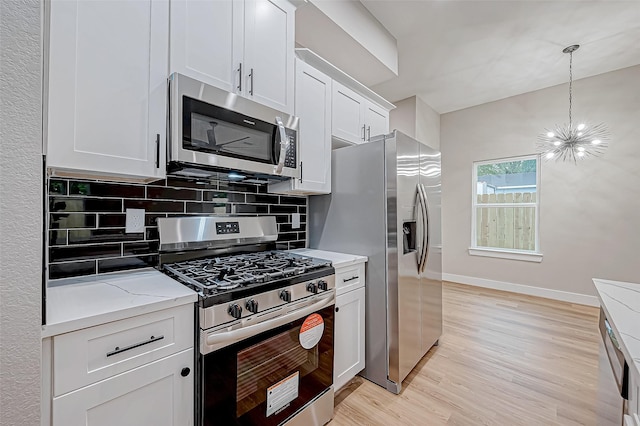 kitchen featuring light hardwood / wood-style floors, white cabinetry, light stone countertops, and stainless steel appliances