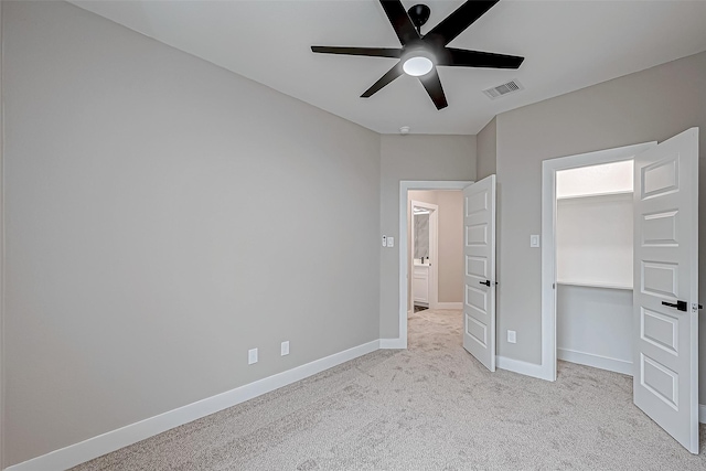 unfurnished bedroom with ceiling fan, light colored carpet, and a closet