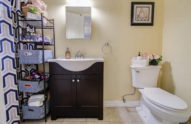 bathroom featuring tile patterned flooring, vanity, and toilet