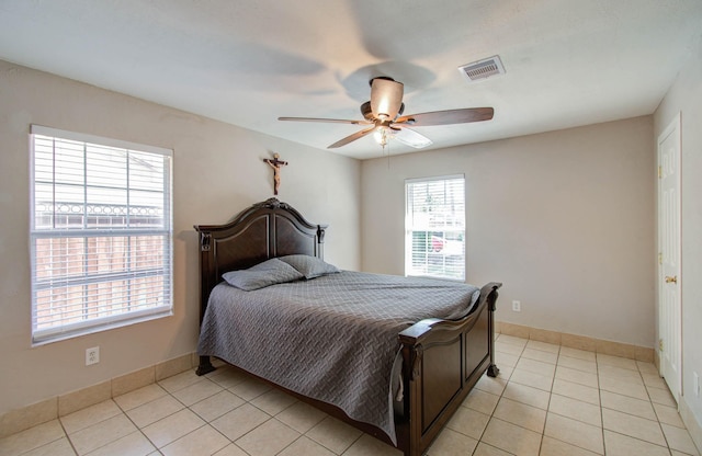 tiled bedroom featuring multiple windows and ceiling fan