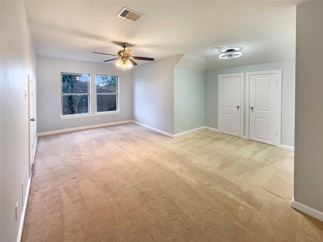 carpeted spare room with ceiling fan