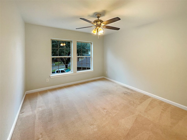 empty room with ceiling fan and light carpet