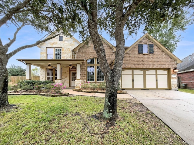 view of front of home with ceiling fan, a garage, and a front yard