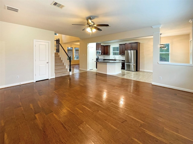 unfurnished living room with hardwood / wood-style flooring and ceiling fan