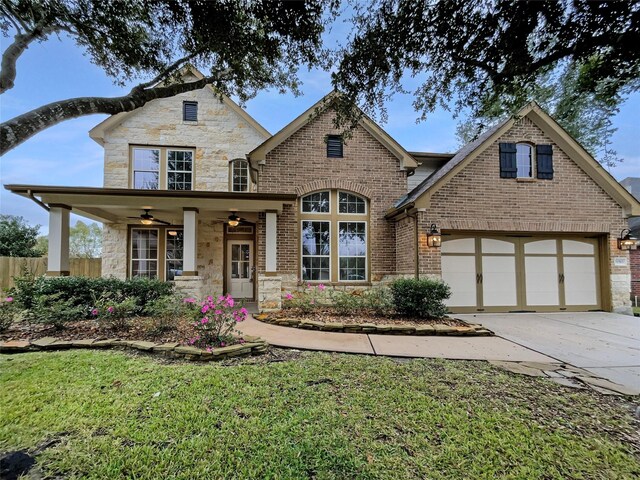 view of front of house with a front yard, a garage, and ceiling fan