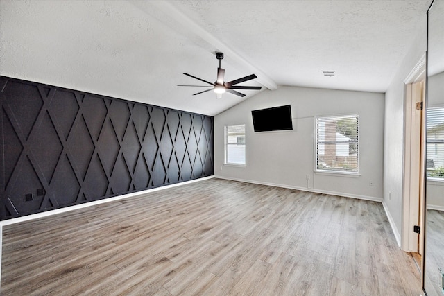 spare room with plenty of natural light, ceiling fan, lofted ceiling with beams, and light hardwood / wood-style flooring