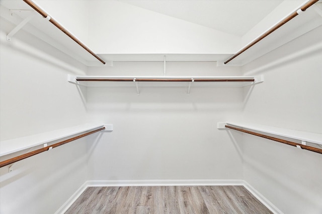 spacious closet with lofted ceiling and light hardwood / wood-style flooring