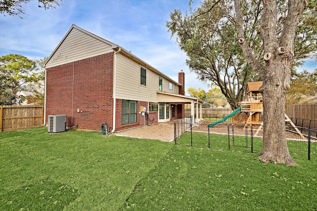 rear view of property with a lawn, a patio area, and a playground