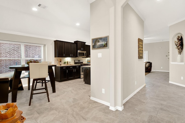 kitchen with appliances with stainless steel finishes, tasteful backsplash, dark brown cabinets, and crown molding