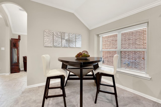 dining room with ornamental molding and lofted ceiling