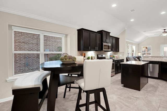 kitchen with a center island, a healthy amount of sunlight, vaulted ceiling, and appliances with stainless steel finishes